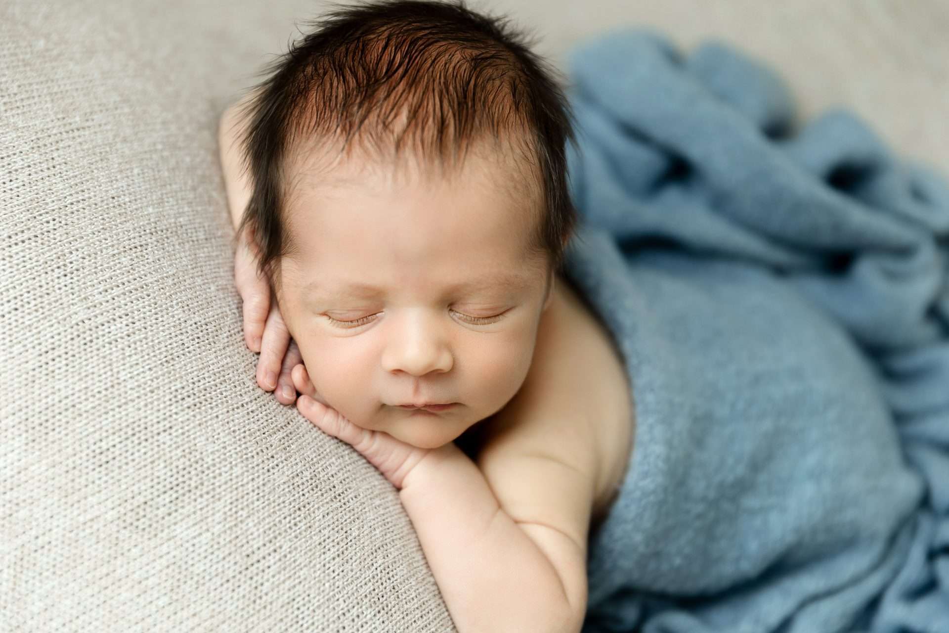 Sleeping newborn boy posed with hands under chin with blue blanket Delano MN Newborn Photographer