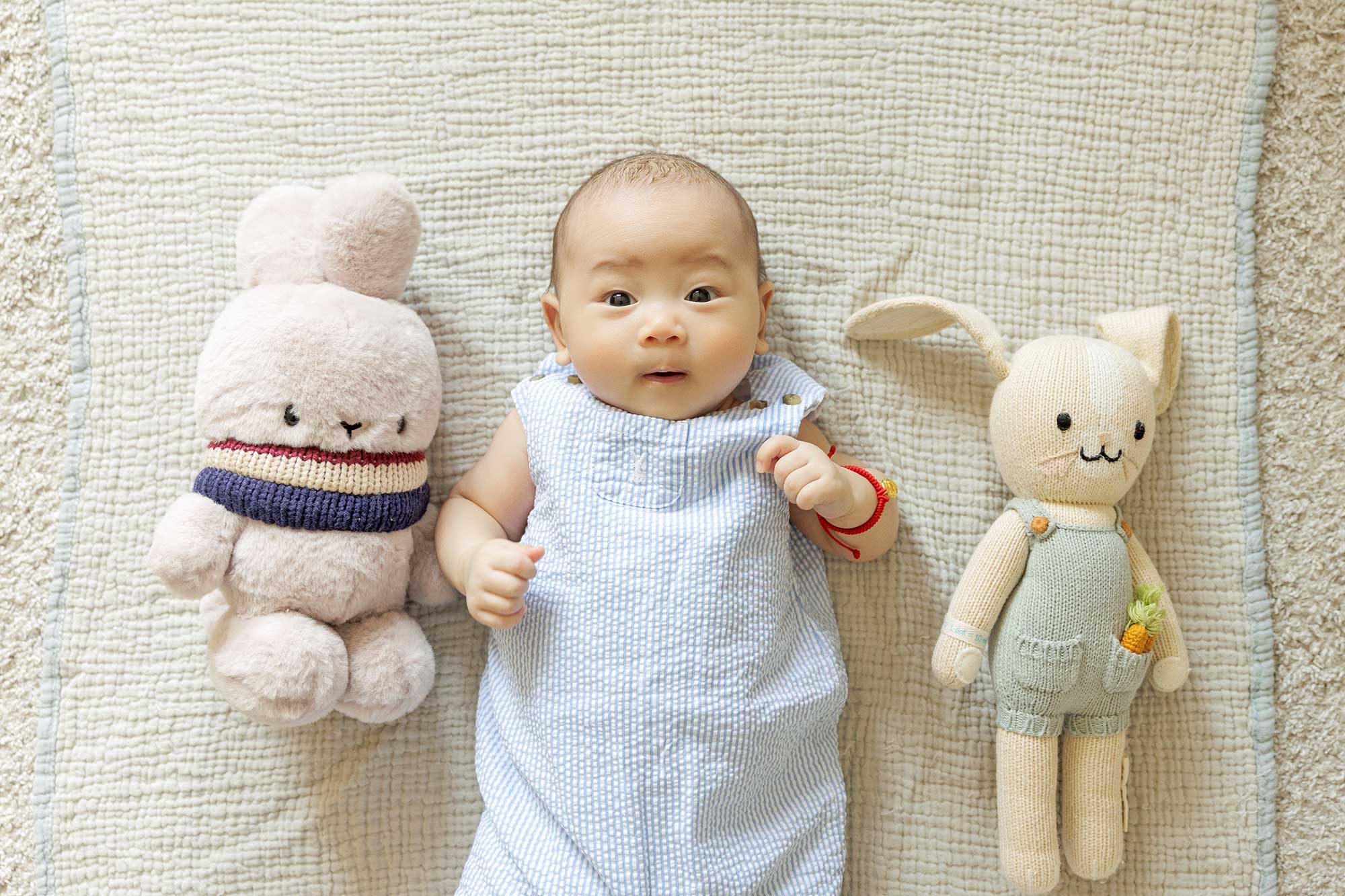 100 day old baby boy posing with stuffed animals