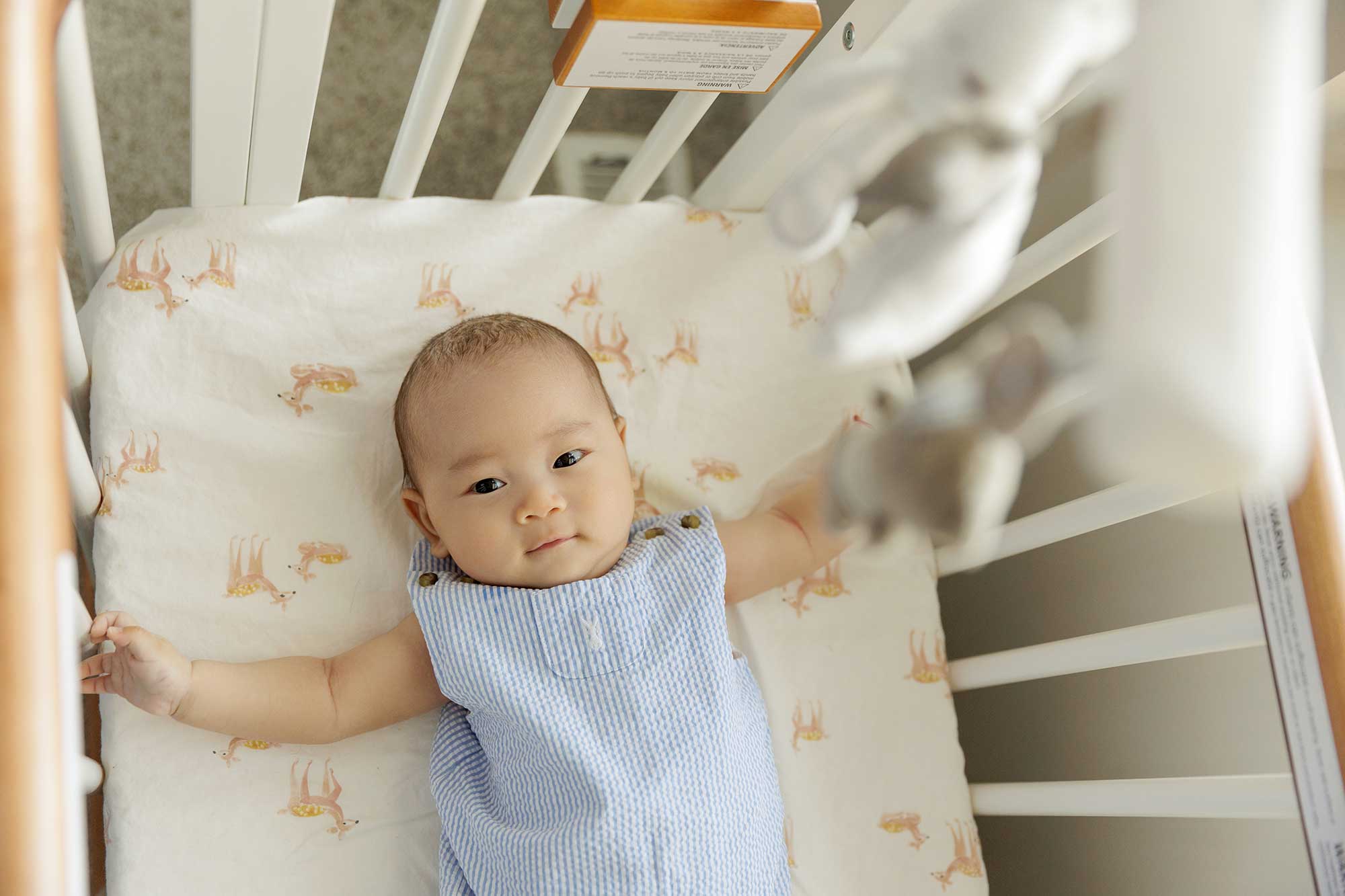 100 days old baby boy lying in crib