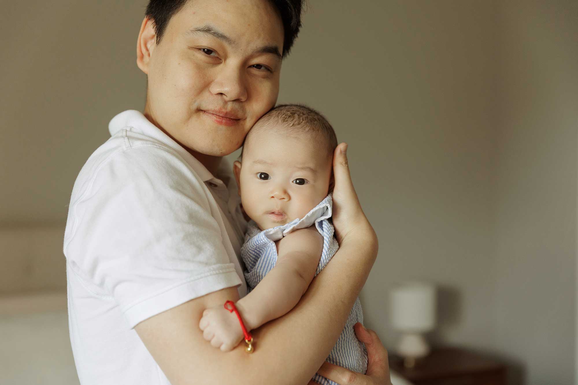 dad holding baby boy for his 100 day celebration