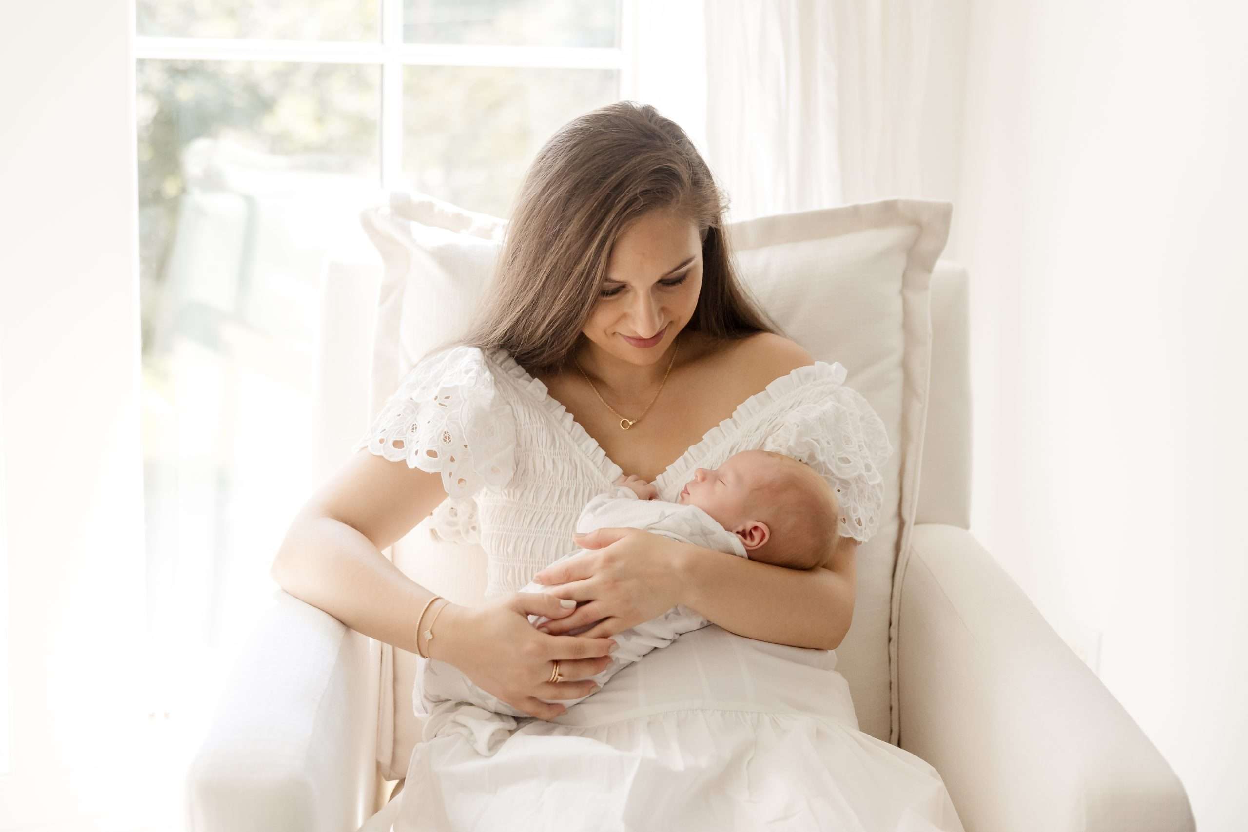 mom holding her baby in nursery
