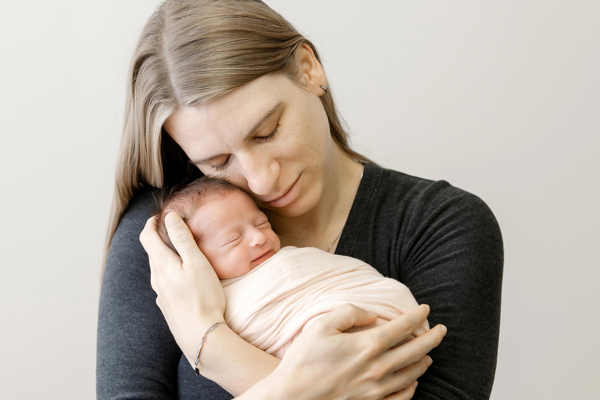 mom holding newborn girl in studio