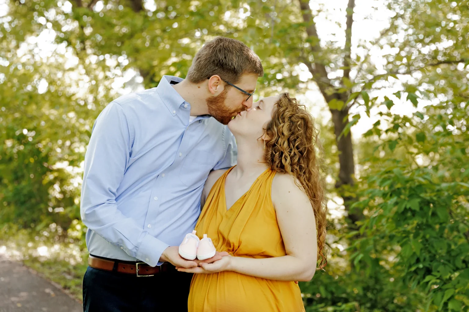pregnant couple posing with baby shoes minneapolis mn