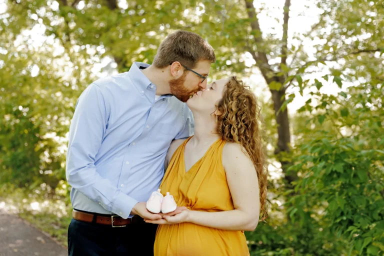pregnant couple posing with baby shoes minneapolis mn