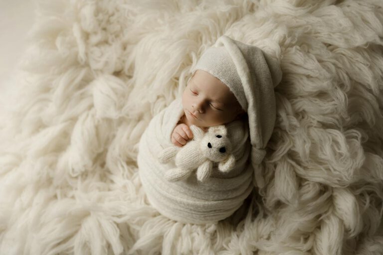 newborn boy wrapped in cream holding a teddy bear with alicea rose photography