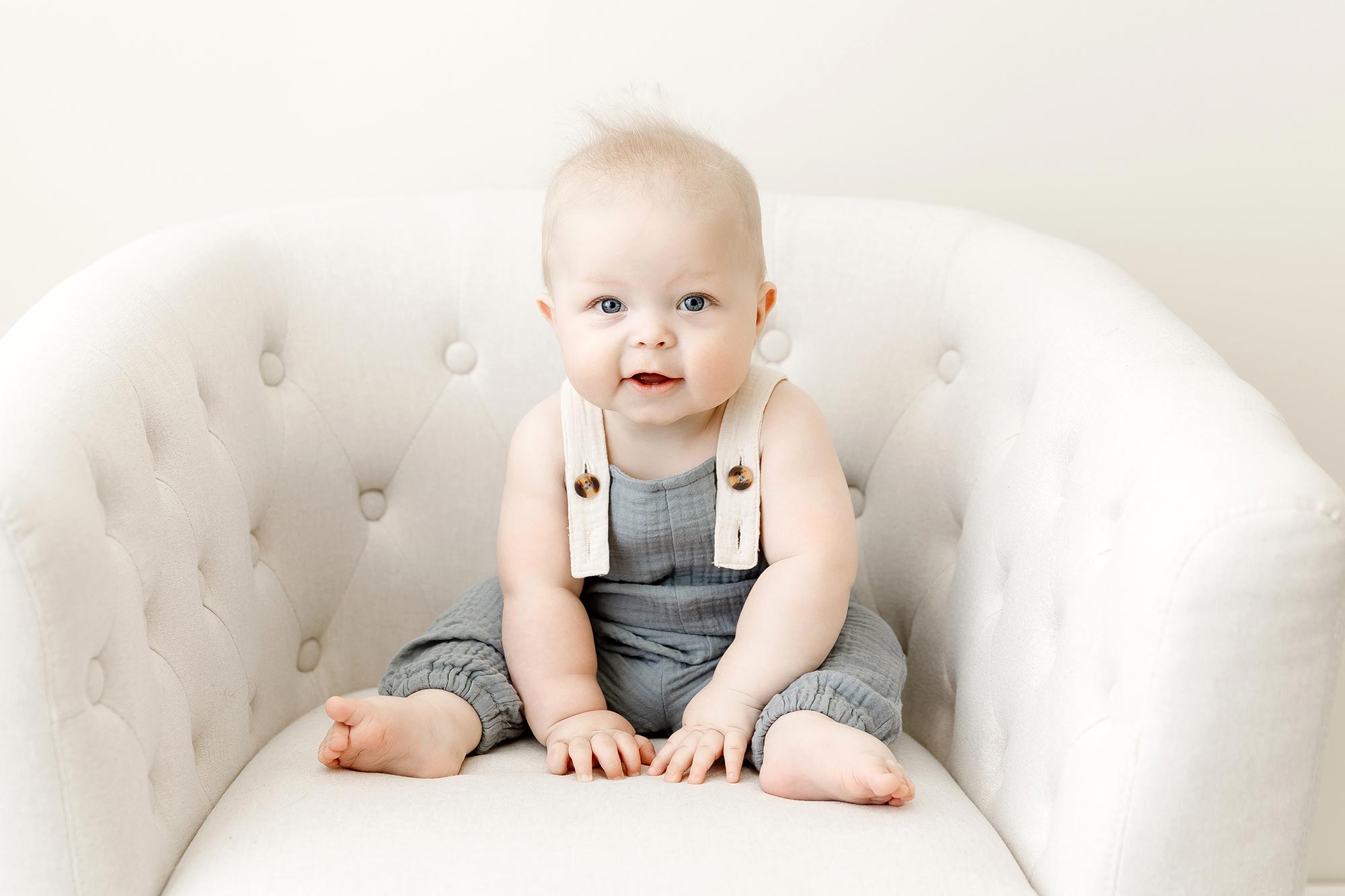 6 month baby boy sitting in a chair for his sitter session at the studio near champlin mn