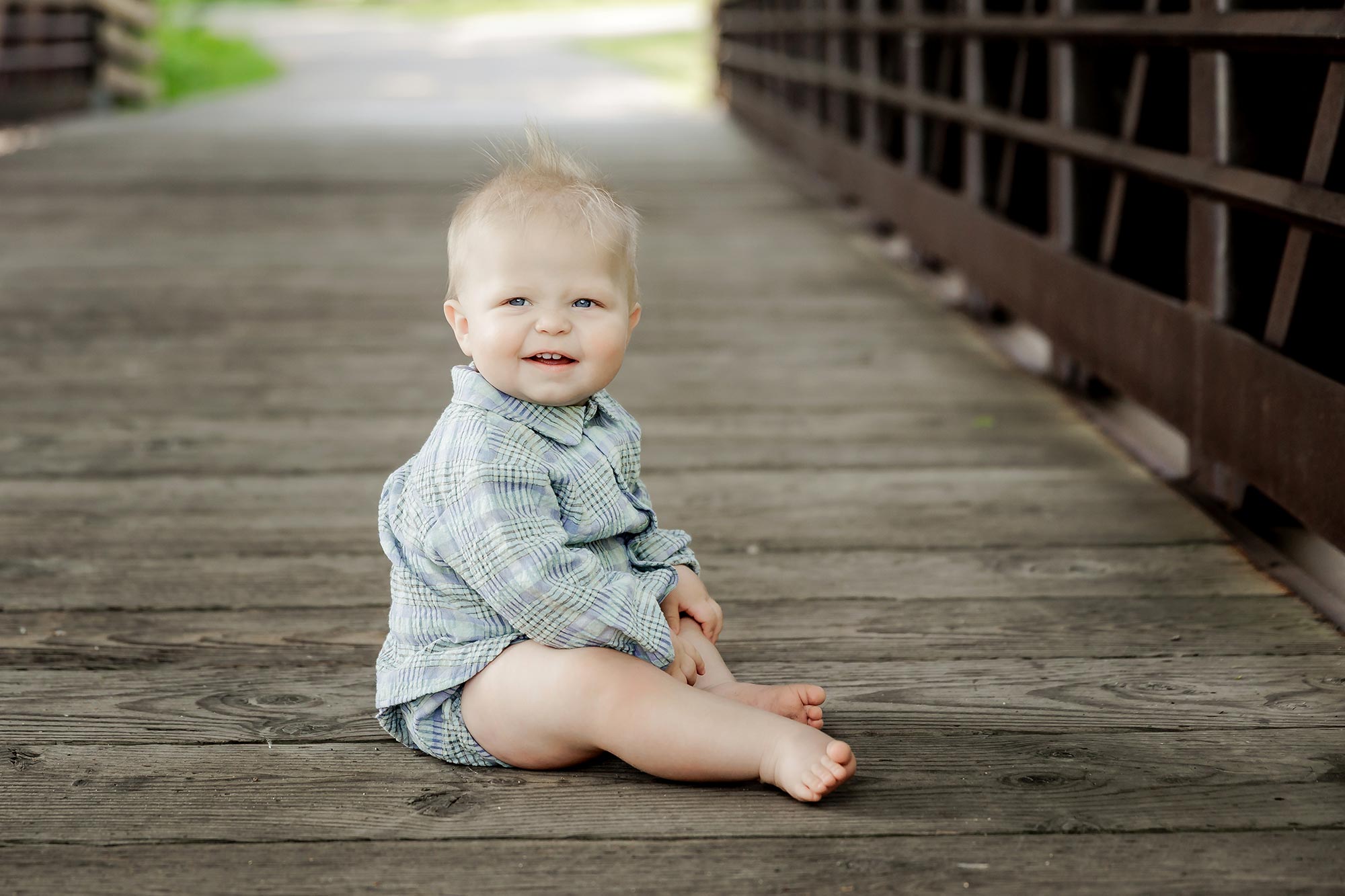 9 month baby portraits of boy sitting on bridge in minneapolis mn