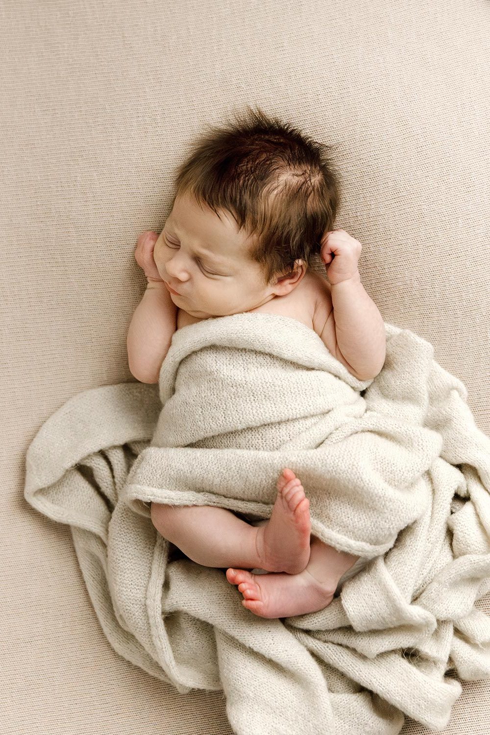 newborn wrapped in cream on pink blanket in twin cities newborn photography studio