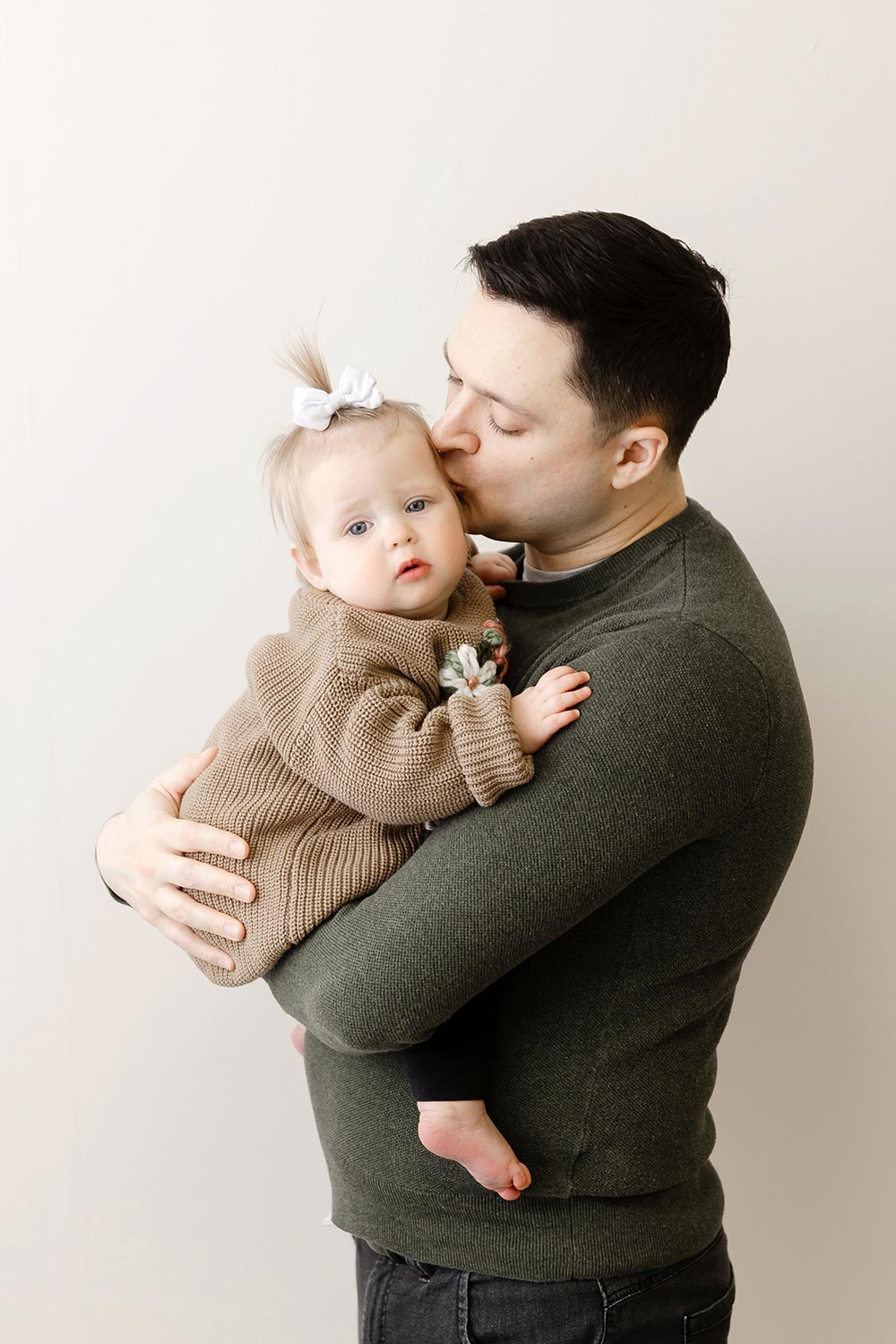 dad holding one year old baby girl in twin cities portrait studio
