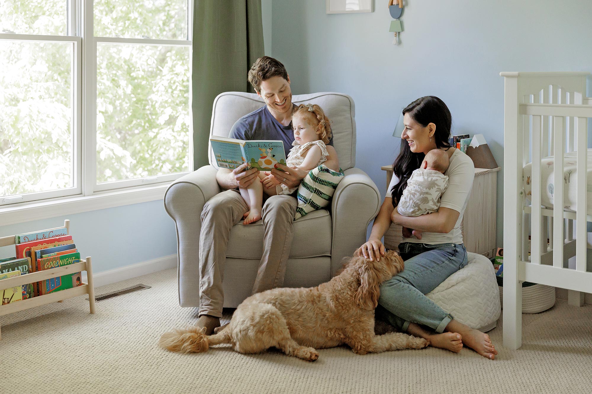 family with toddler, newborn and dog sitting in nursery in minneapolis mn