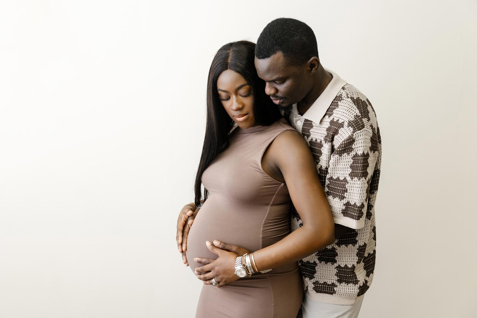pregnant couple holding belly in MINNEAPOLIS portrit studio