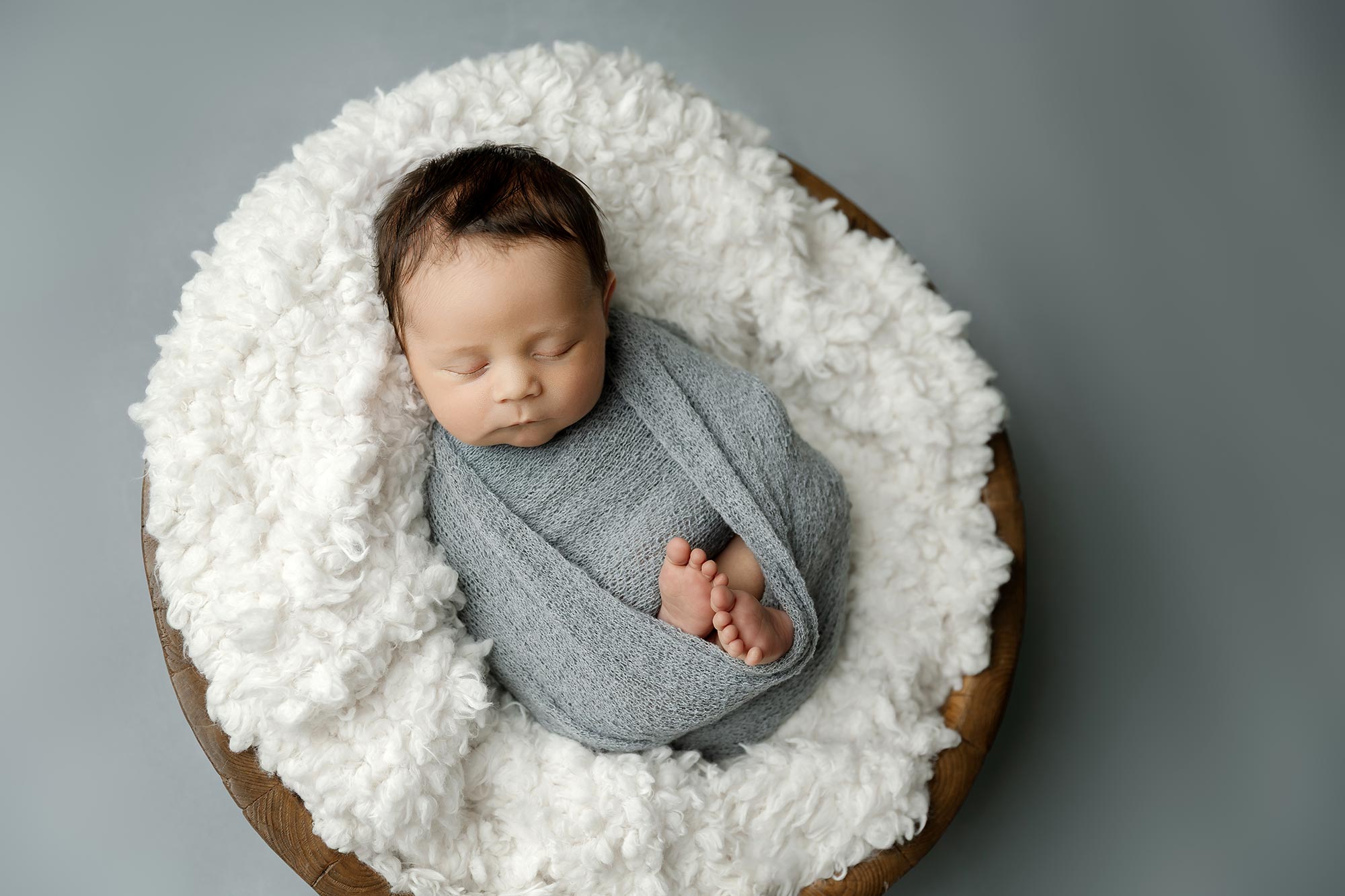 sleeping newborn baby boy wrapped in blue in the studio near wayzata mn