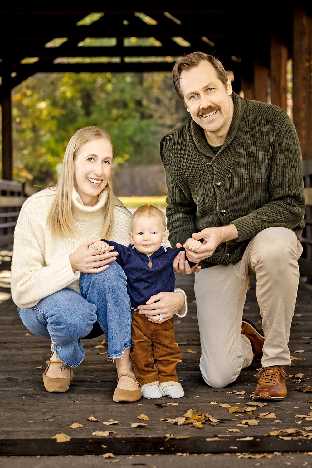 couple posing with 6 month baby boy outdoors in the fall in minneapolis