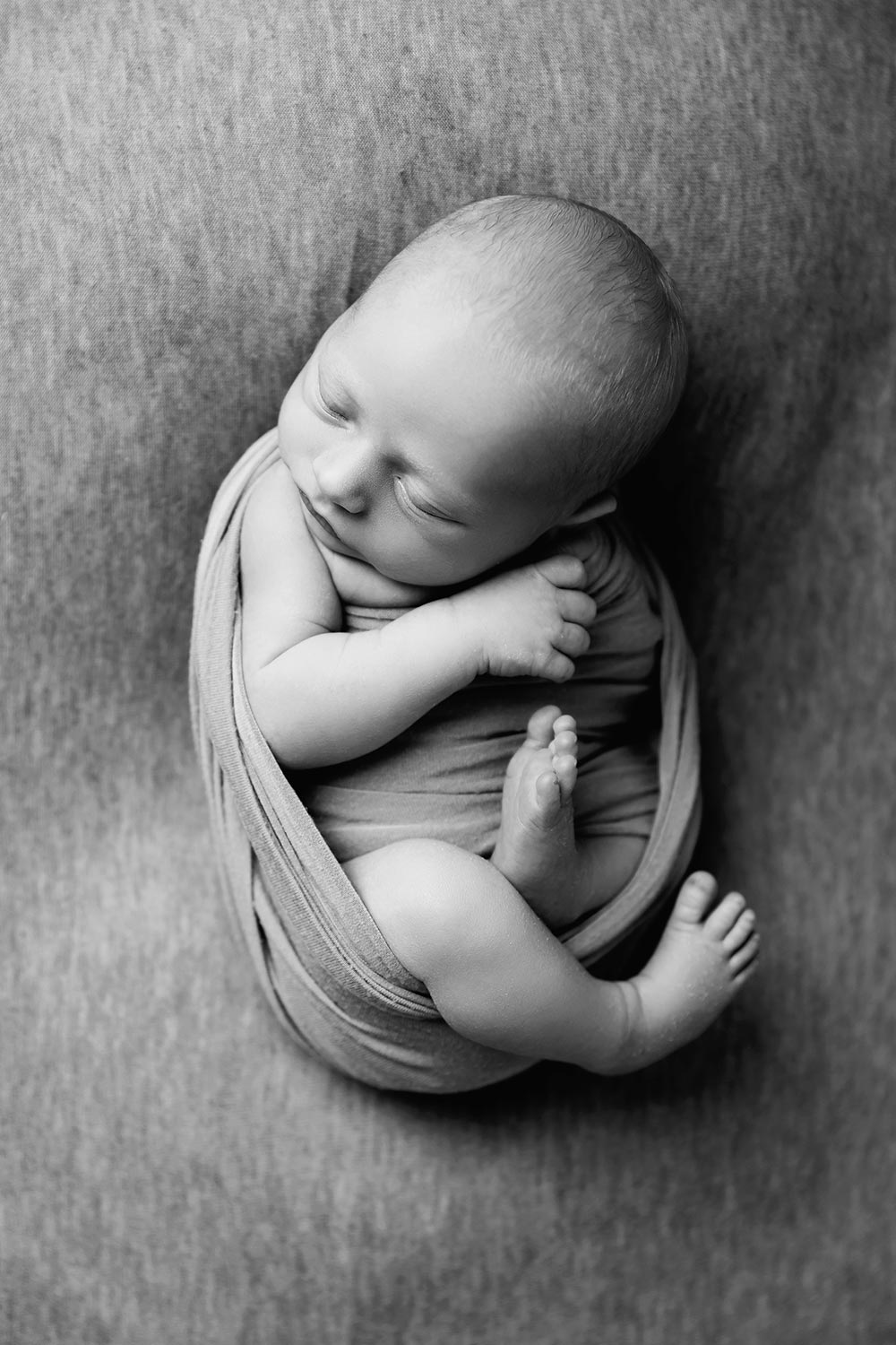wrapped newborn boy in black and white in minneapolis studio