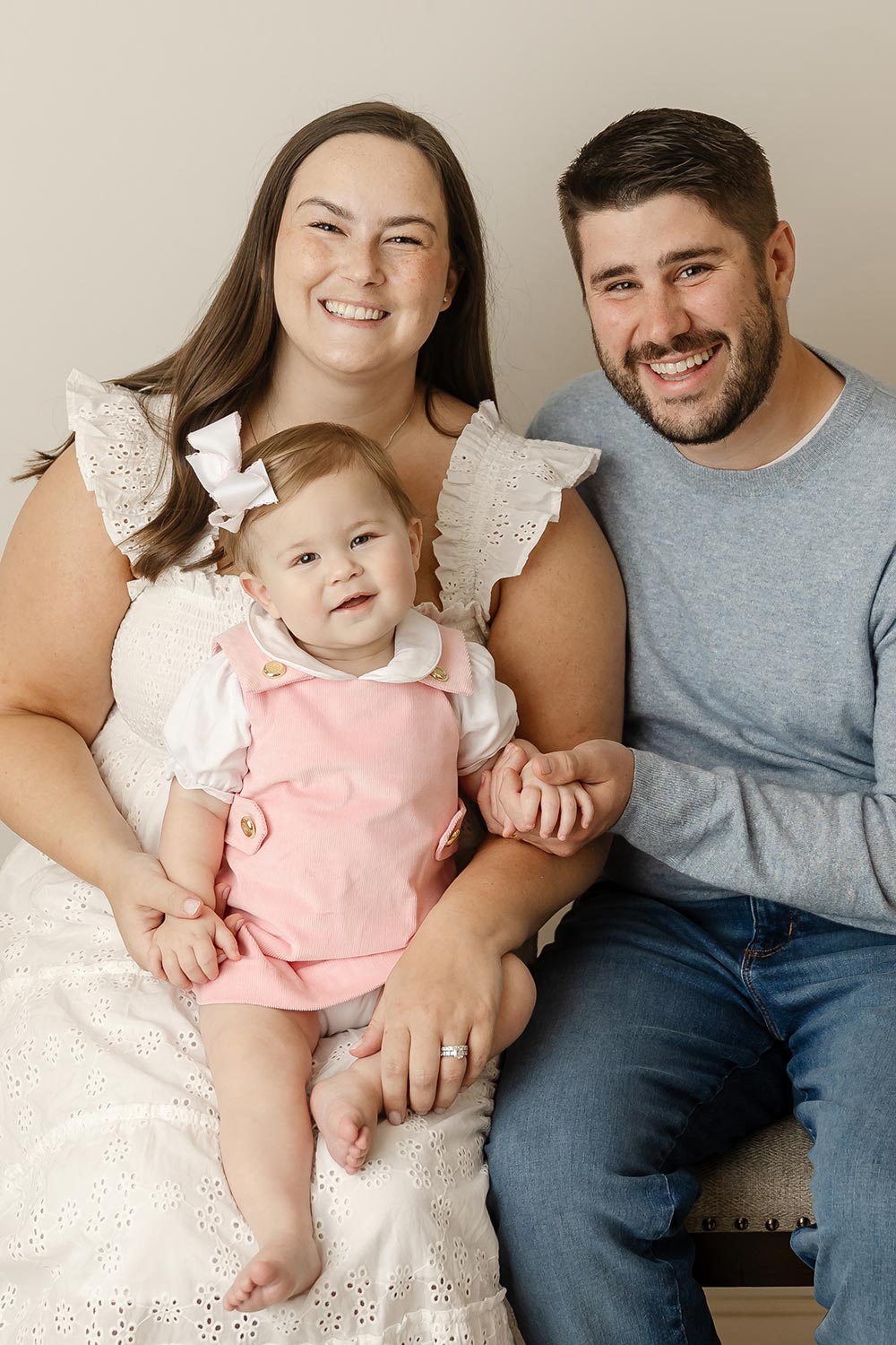 family photo of parents holding one year old baby girl in minneapolis baby photography studio
