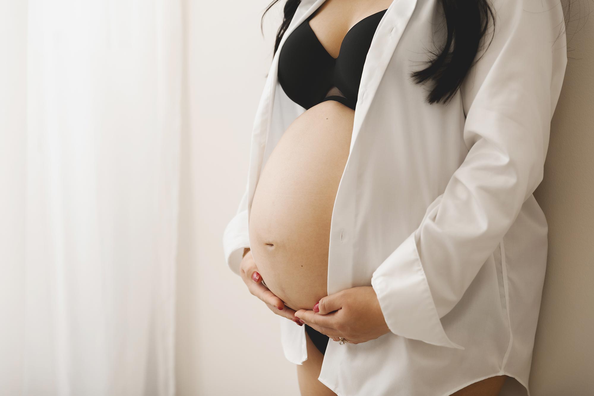 pregnant mom to be holding her belly at the studio near wayzata mn