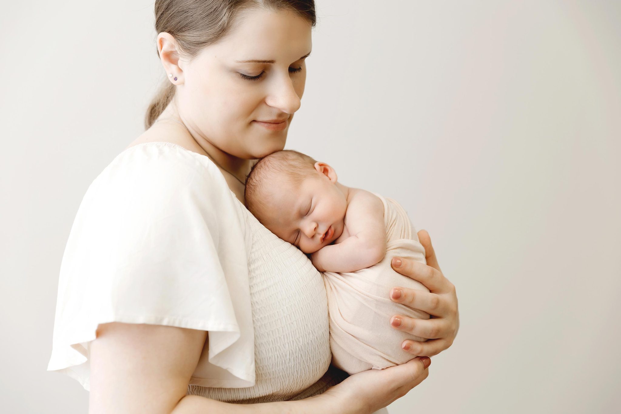 mom holding her newborn baby girl in a studio in minneapolis mn